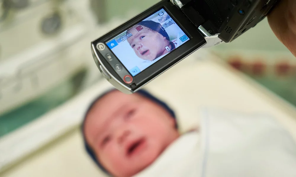 Newborn baby being filmed