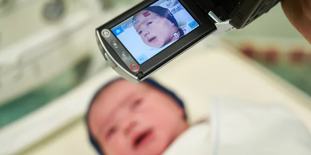 Newborn baby being filmed