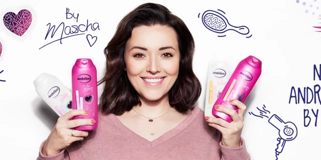 A smiling Masha holding beauty products in her hands