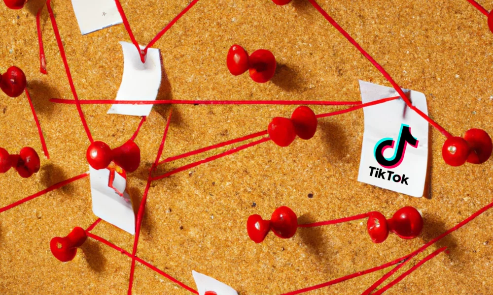 cork board with pieces of paper connected with red string, one piece has the TikTok logo on it