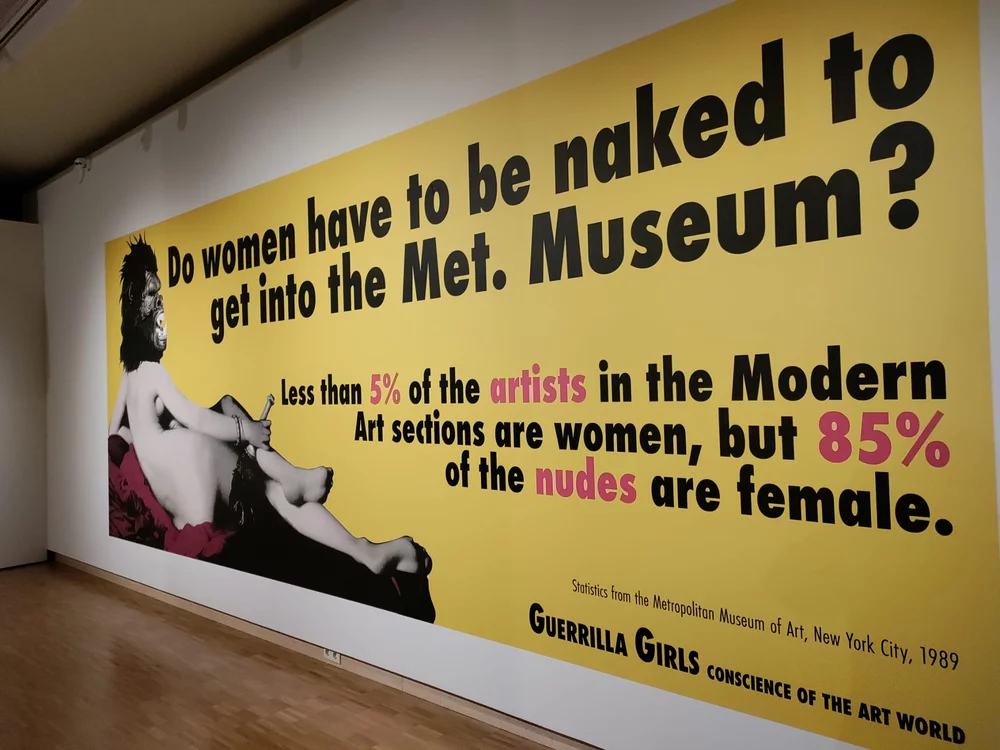 Picture of a bright yellow artwork adressing inequality in the artworld by the Guerilla Girls